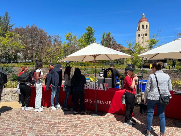 Five students lined up at booth outside on Stanford campus