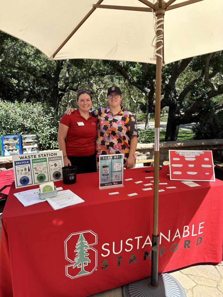 Two people standing behind Stanford booth at Event Planners Summit
