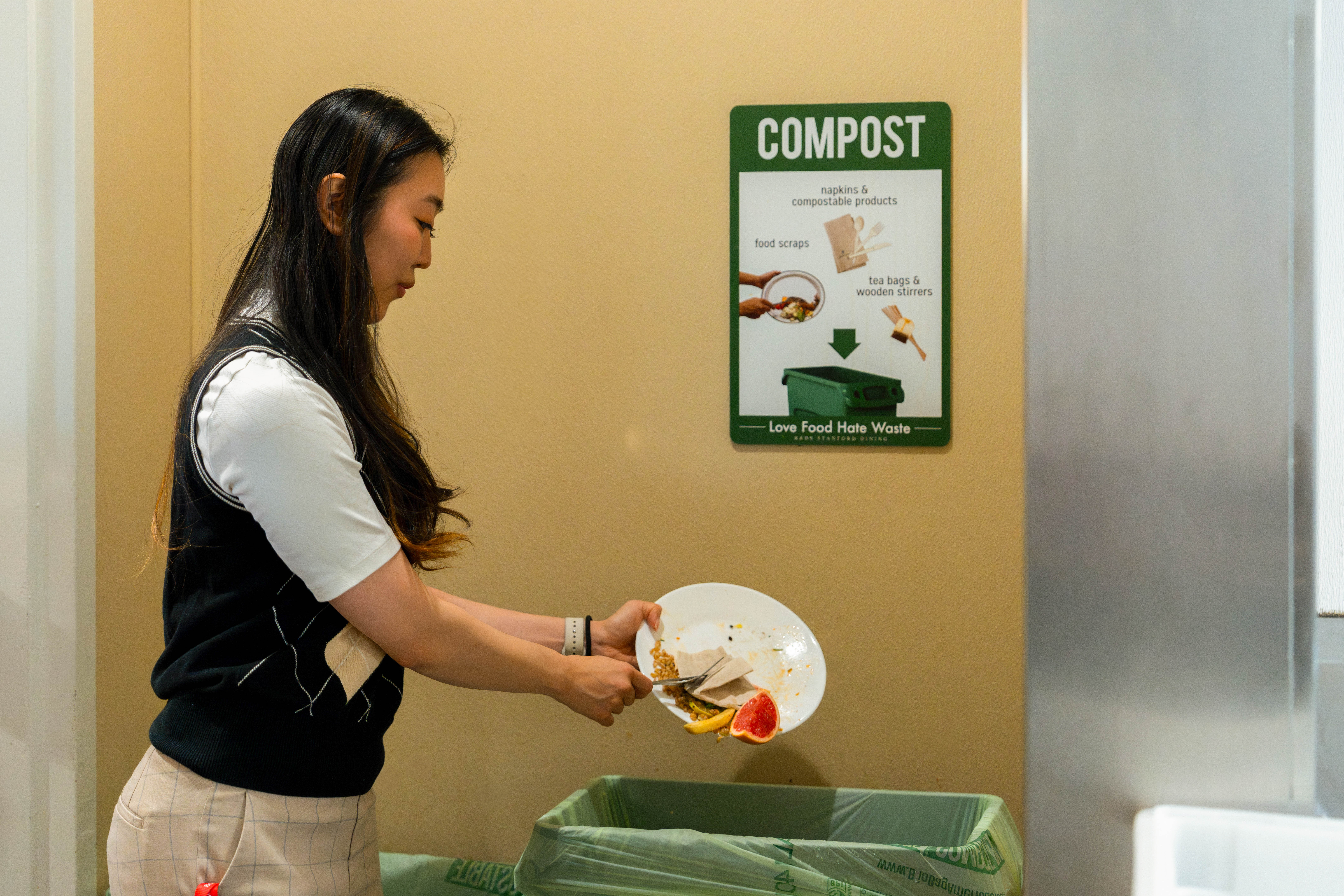 Person scraping food into a compost bin
