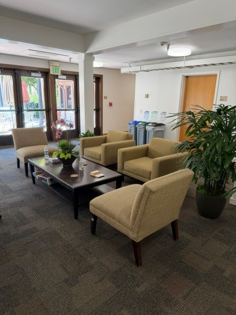 The lobby of a building with four chairs and a coffee table.