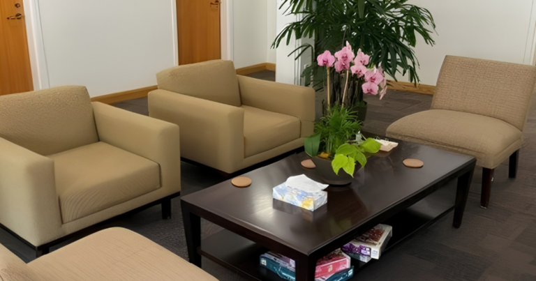 The lobby of a building with four chairs and a coffee table.